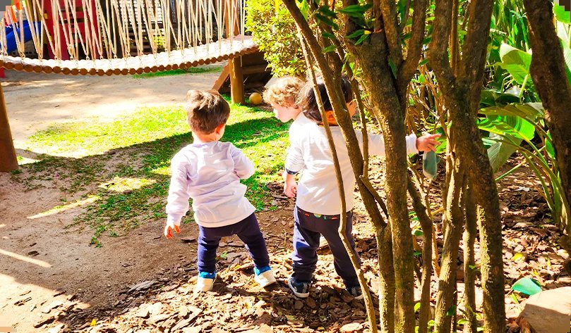 Crianças pequenas explorando o jardim da escola