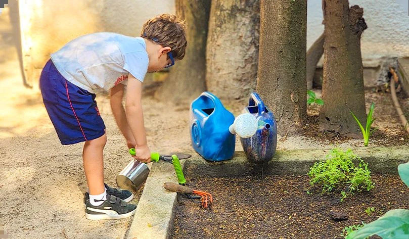 Criança cuidando da horta da escola