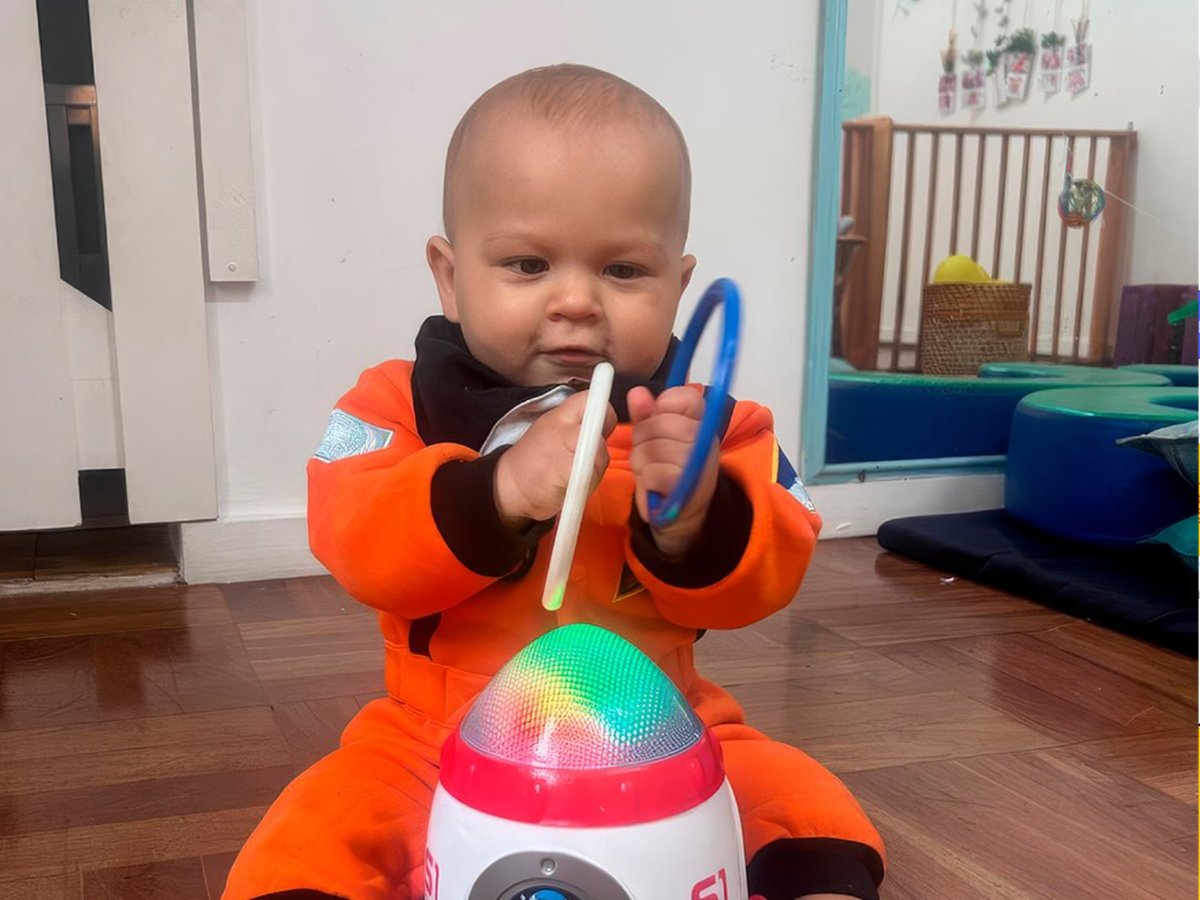 Bebê do Berçário brincando sentado no chão da sala