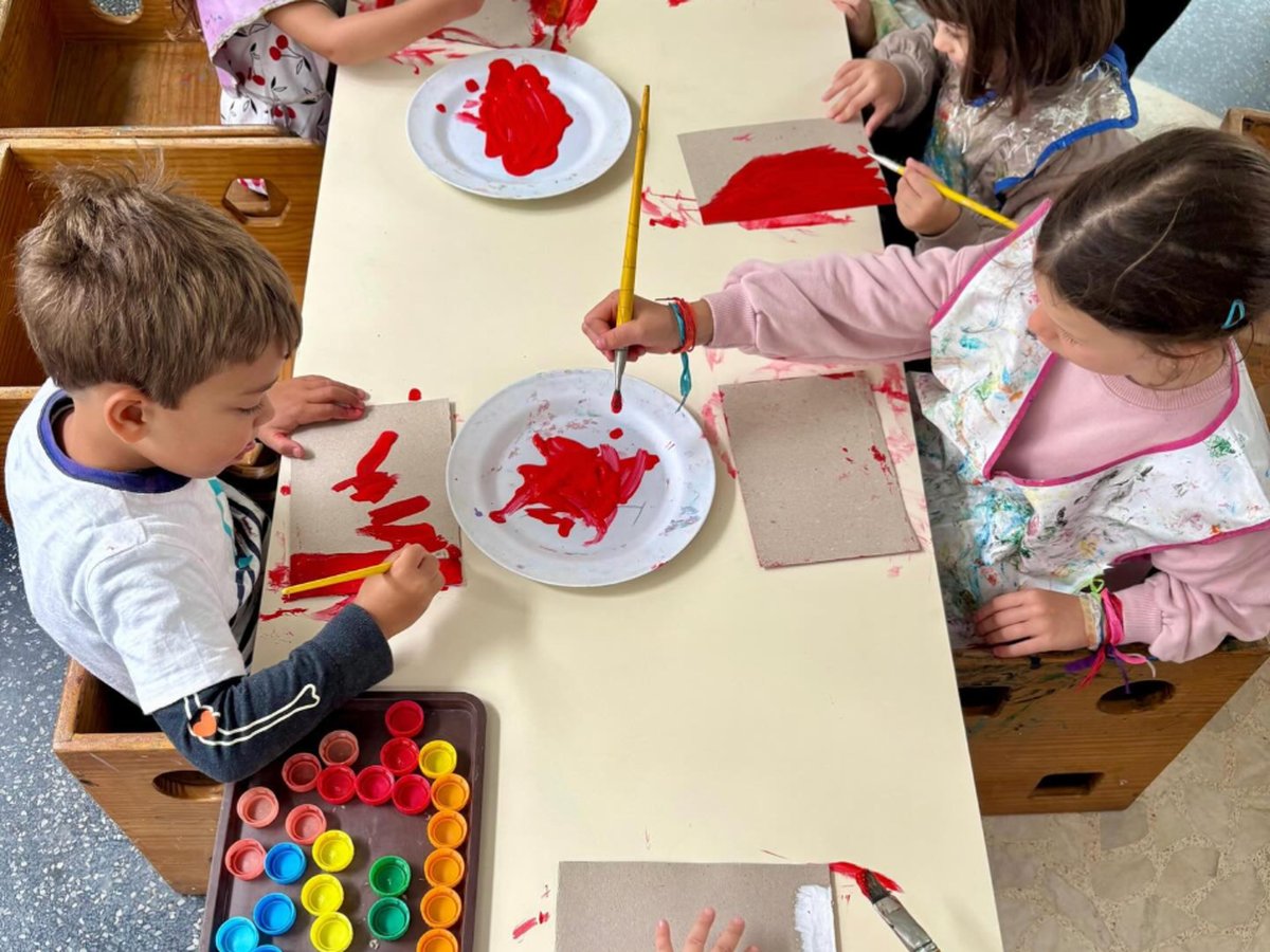 Crianças da Educação Infantil pintando juntas em uma mesa da All Together