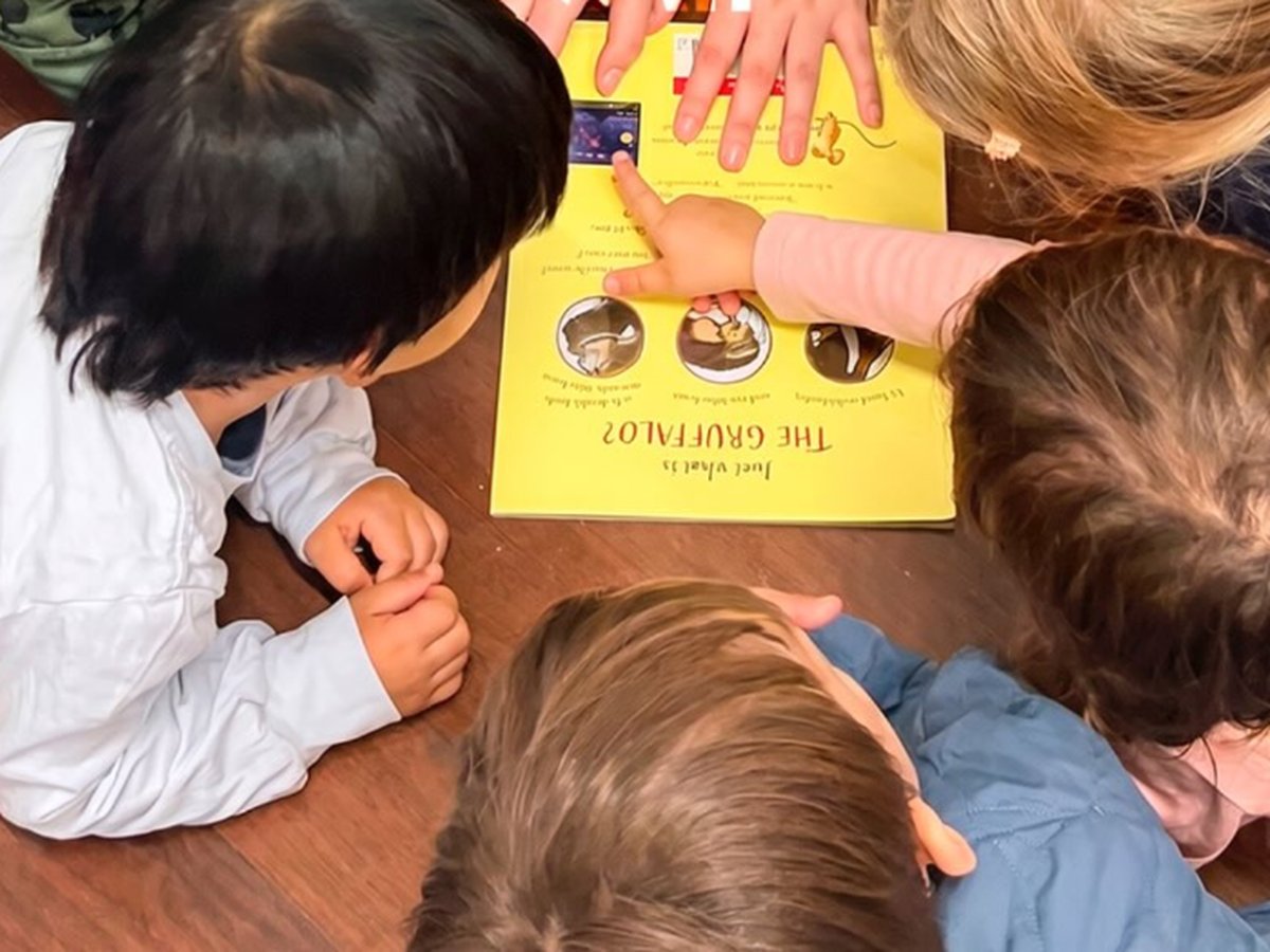 Professora lendo The Gruffalo, em inglês, com as crianças no story time